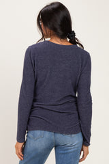 woman wearing a navy long sleeve top with a relaxed fit paired with light blue jeans, viewed from the back
