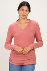 woman wearing a rose pink long sleeve v-neck top with gathered sides and a relaxed fit