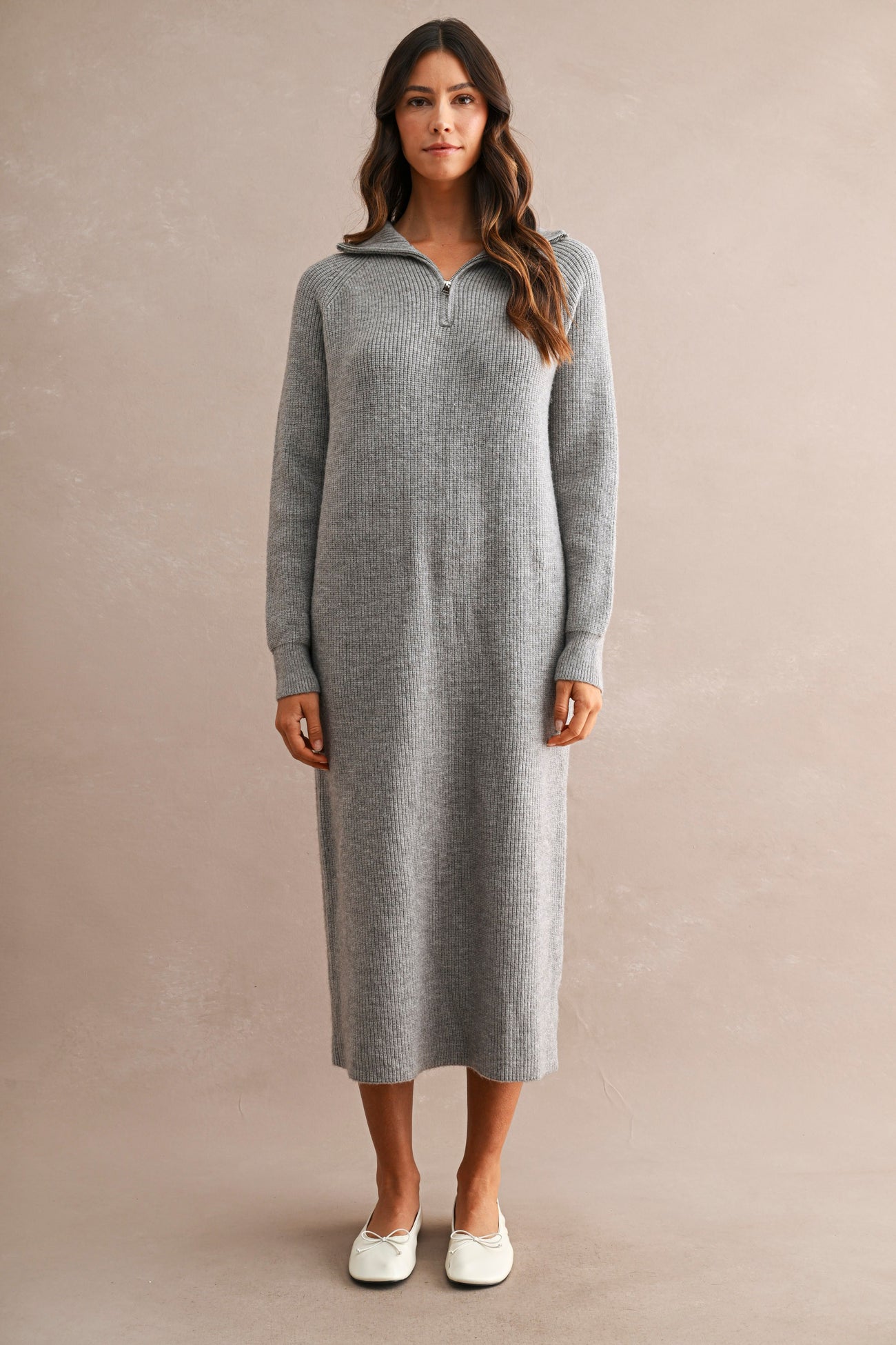 woman wearing a gray knit midi dress with a half-zip collar and long sleeves