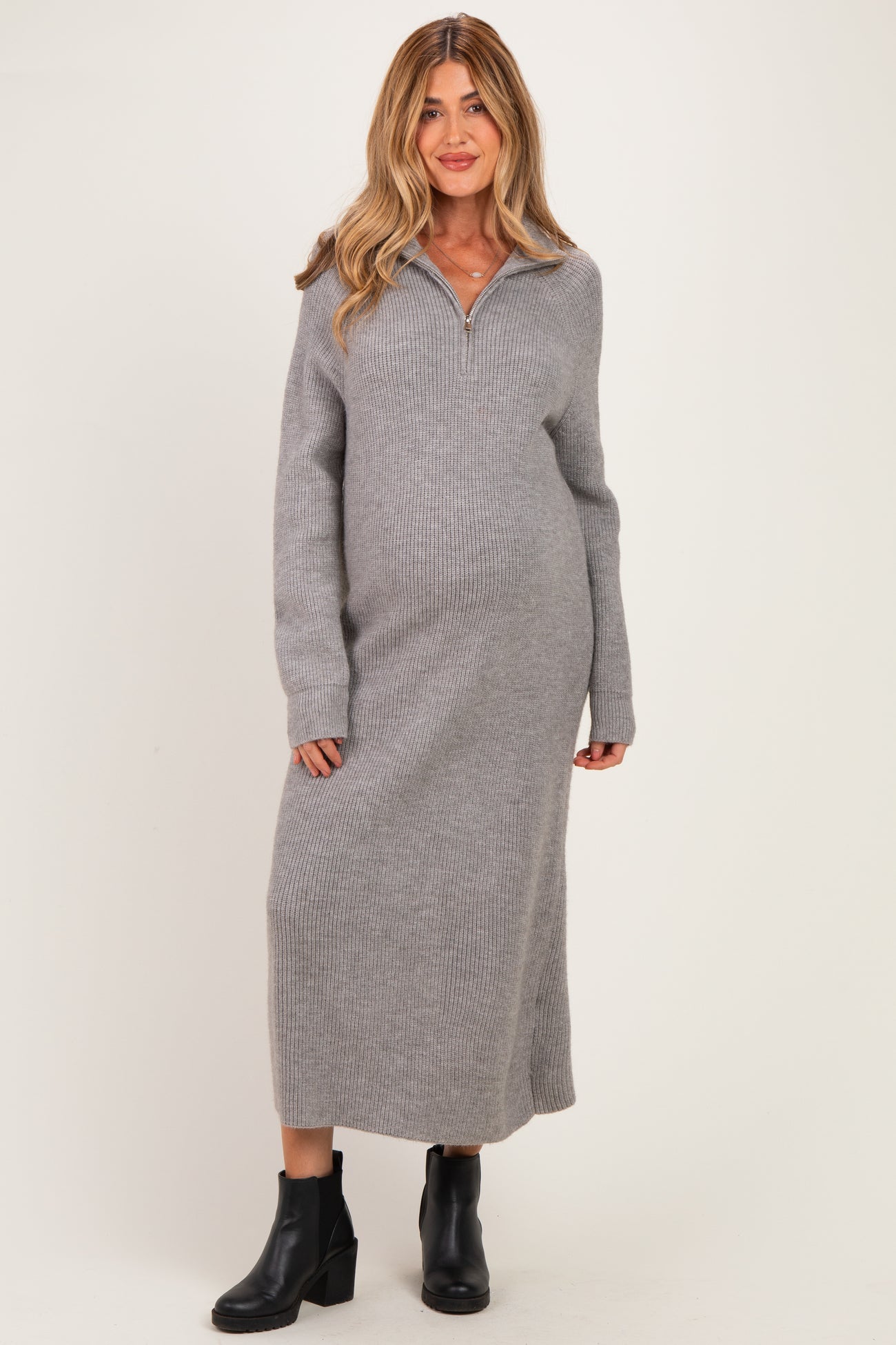 woman wearing a gray long sleeve maternity sweater dress with a collar and a visible baby bump