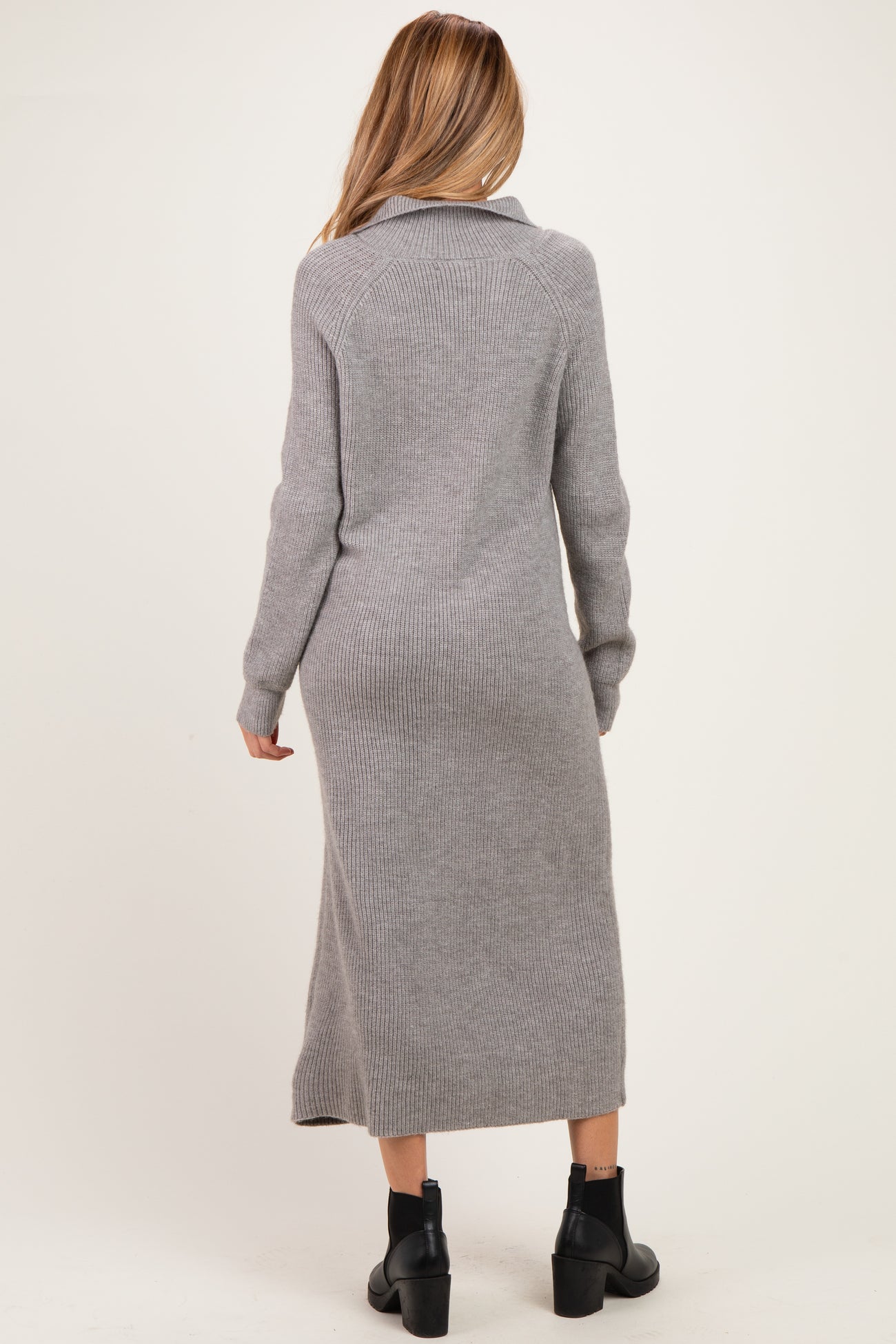 woman wearing a long gray maternity sweater dress with a fitted silhouette and a collar, viewed from the back