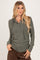 woman wearing a dark green long sleeve hooded henley top with buttons and a relaxed fit
