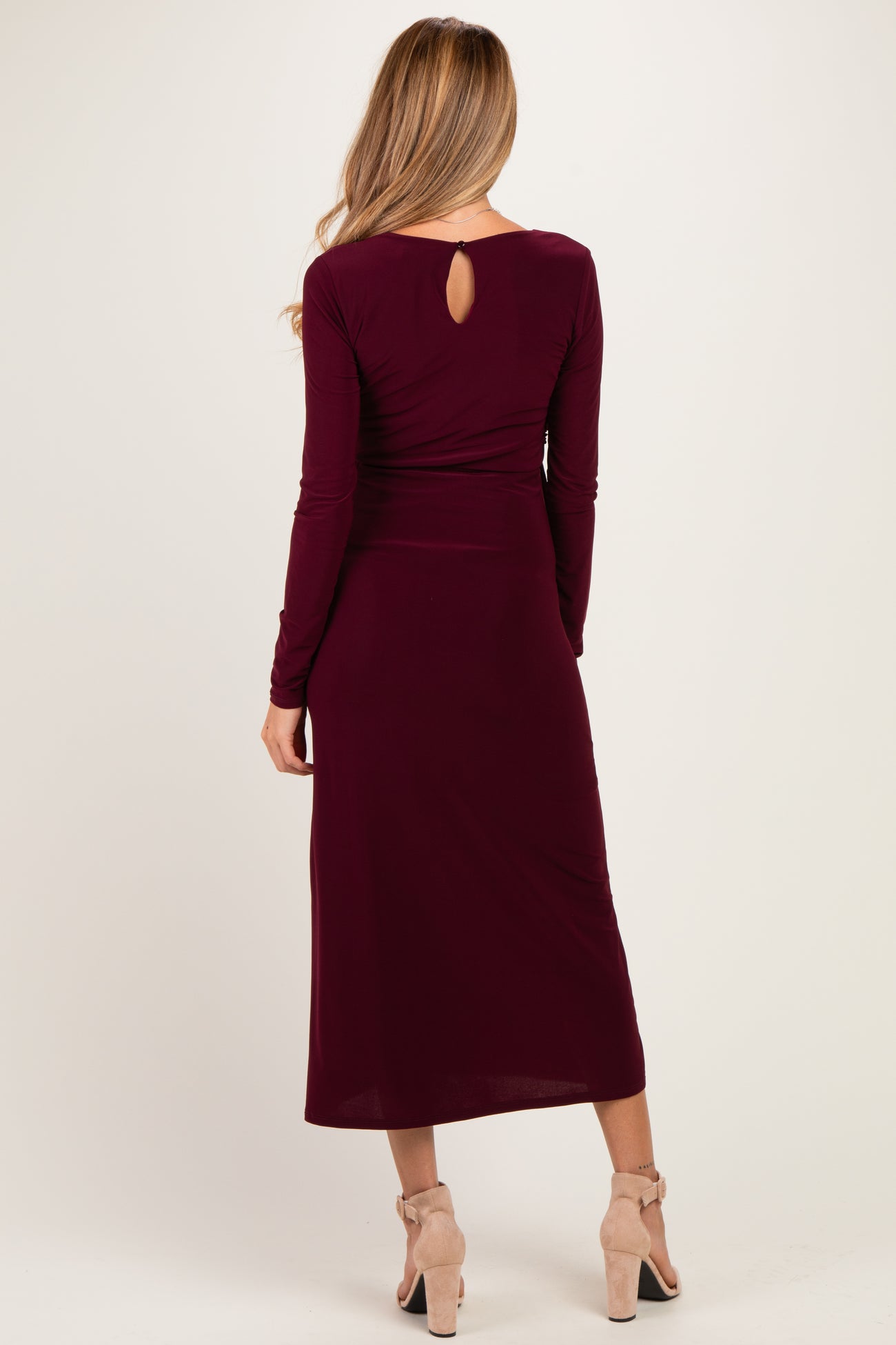 woman wearing a burgundy long sleeve maternity dress with a keyhole back detail