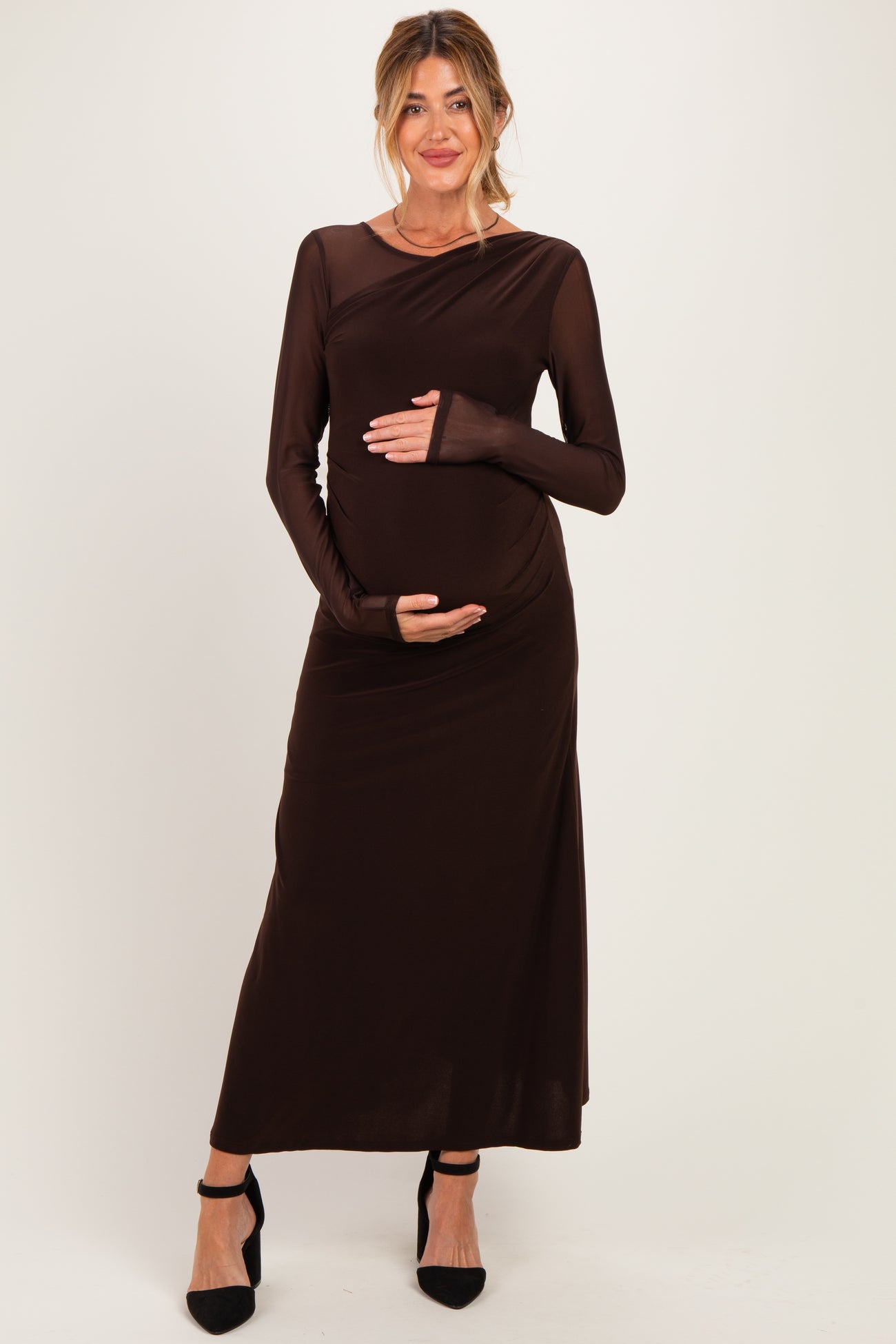 woman wearing a brown long sleeve maternity dress and holding her baby bump