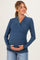 woman wearing a dark blue maternity wrap top and holding her baby bump