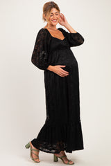 woman wearing a black lace maternity maxi dress with long sleeves and a baby bump