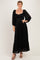 woman wearing a black lace maxi dress with long puff sleeves and a ruffled hemline