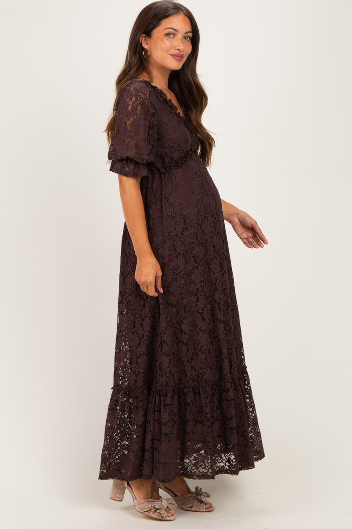 woman wearing a brown lace maternity maxi dress with short sleeves and a visible baby bump