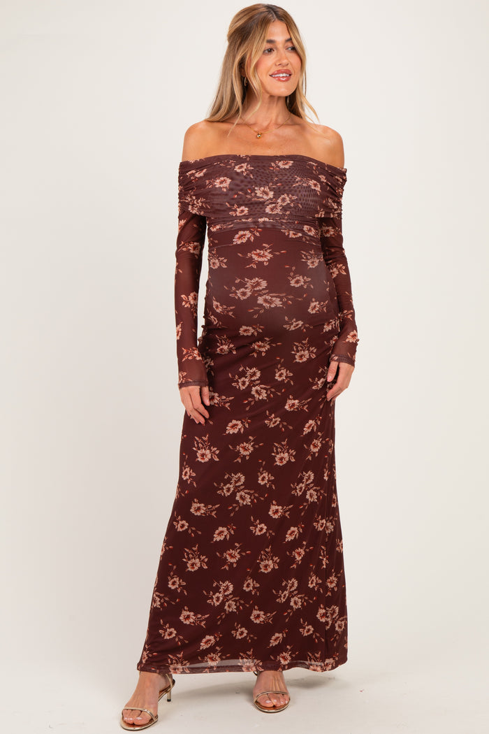 woman wearing a burgundy off-the-shoulder maternity dress with floral print and a visible baby bump