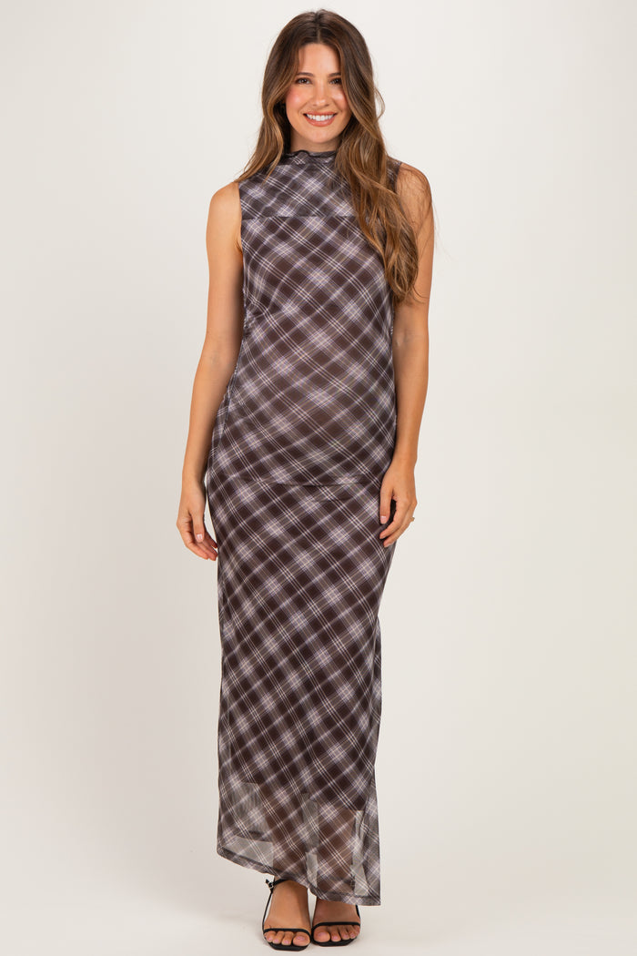 woman wearing a black and white plaid maternity maxi dress with a high neckline and a form-fitting silhouette, showcasing her baby bump