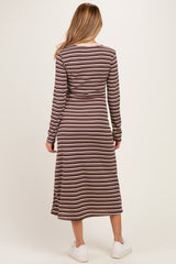 woman wearing a long sleeve brown and cream striped maternity dress with a midi length and side slits