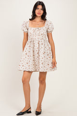 woman wearing a cream floral print puff sleeve mini dress and black flats