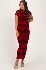 woman wearing a burgundy floral lace maternity dress that hugs her curves and showcases her baby bump