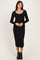 woman wearing a black long sleeve midi dress with a scoop neckline and a fitted silhouette