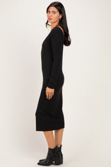 woman wearing a black long sleeve bodycon midi dress with a fitted silhouette and side slit, standing in profile