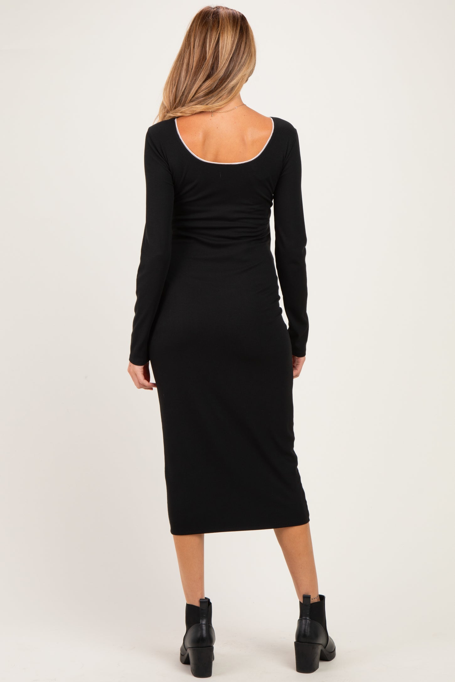 woman wearing a black long sleeve maternity dress, fitted style, showing the back view
