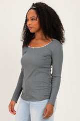 woman wearing a grey long sleeve fitted top with a scoop neckline and decorative stitching