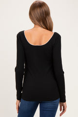 woman wearing a black long sleeve maternity top with a scoop back and stylish ribbed texture