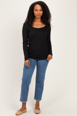 woman wearing a black long sleeve top and blue cropped jeans with beige flats