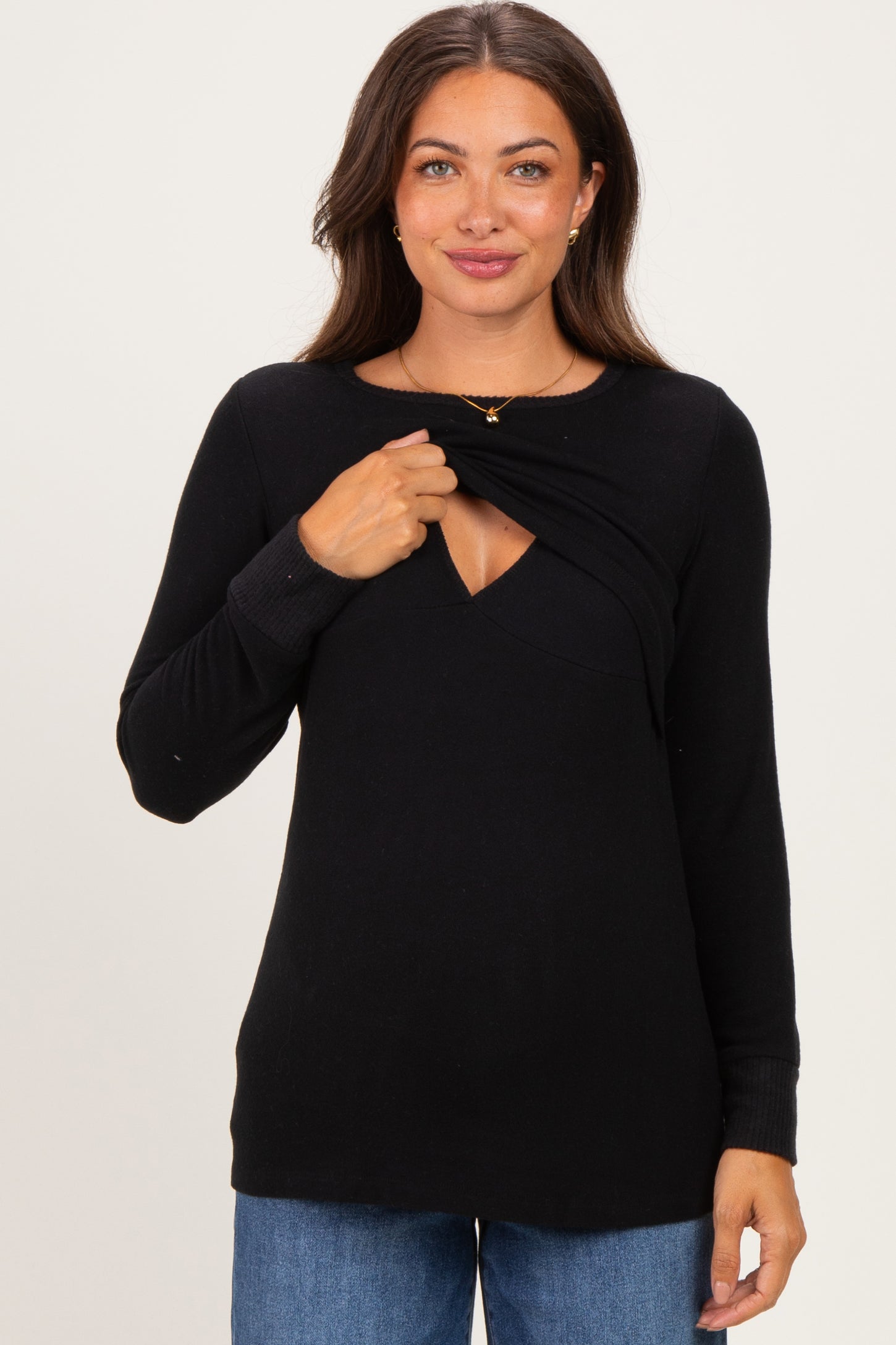 woman wearing a black maternity sweater with a scoop neckline and a layered design for easy nursing access