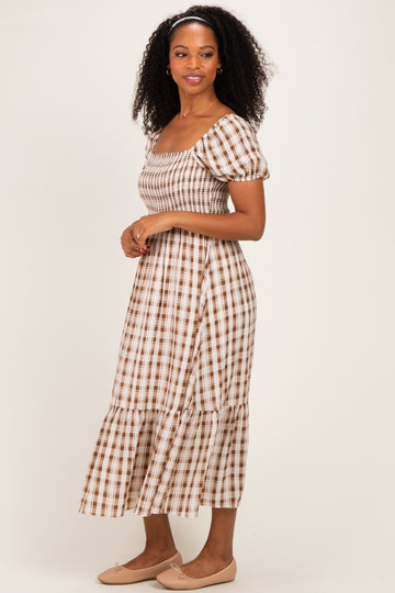 woman wearing a brown and white checked midi dress with puff sleeves and a tiered skirt