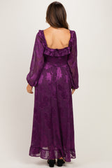 woman wearing a purple floral maxi maternity dress with long sleeves and a smocked waist, showing a baby bump