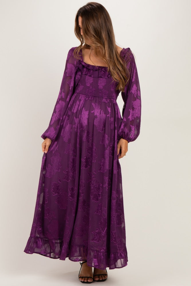 woman wearing a purple floral maternity maxi dress with puff sleeves and a smocked bodice, showcasing her baby bump