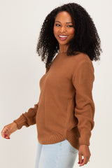 woman wearing a brown textured sweater with long sleeves and a relaxed fit, smiling and facing to the side