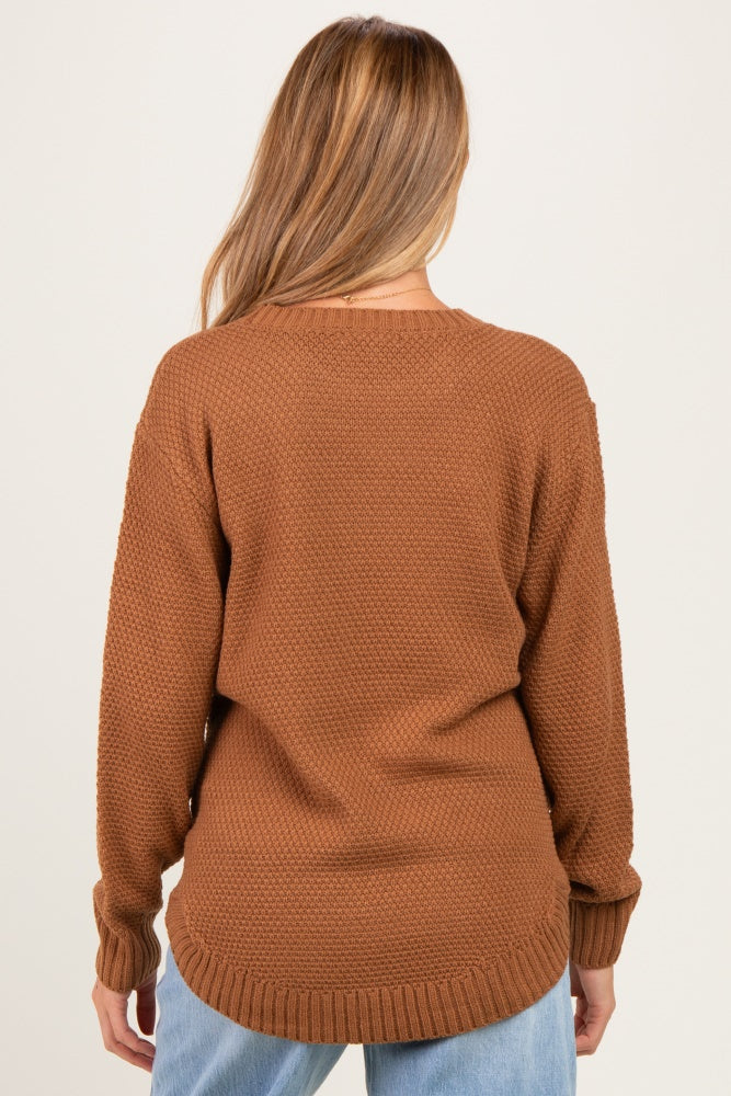 woman wearing a brown textured maternity sweater with a relaxed fit and long sleeves, viewed from the back