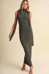 woman wearing a dark green sleeveless maxi dress with side slits and a high neckline