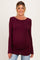 woman wearing a burgundy long sleeve maternity top and showing her baby bump