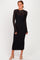 woman wearing a long sleeve black fitted dress with lace details and a midi length, standing and smiling