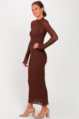 woman wearing a brown long sleeve knitted dress with a fitted silhouette and side slit, paired with beige heels