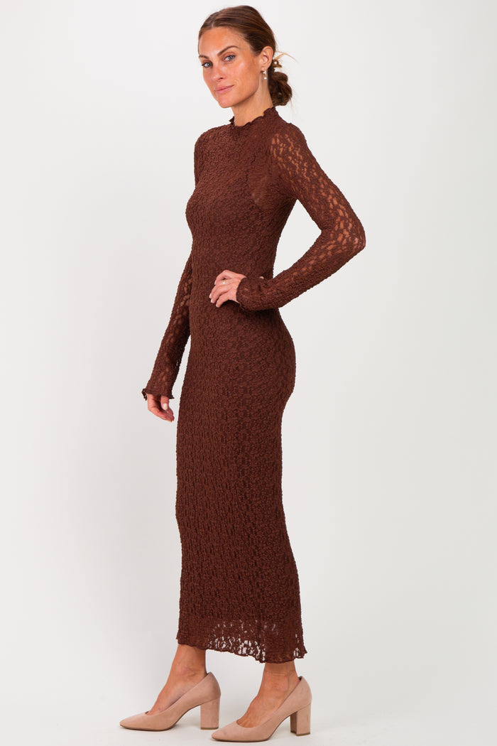 woman wearing a brown long sleeve knitted dress with a fitted silhouette and side slit, paired with beige heels