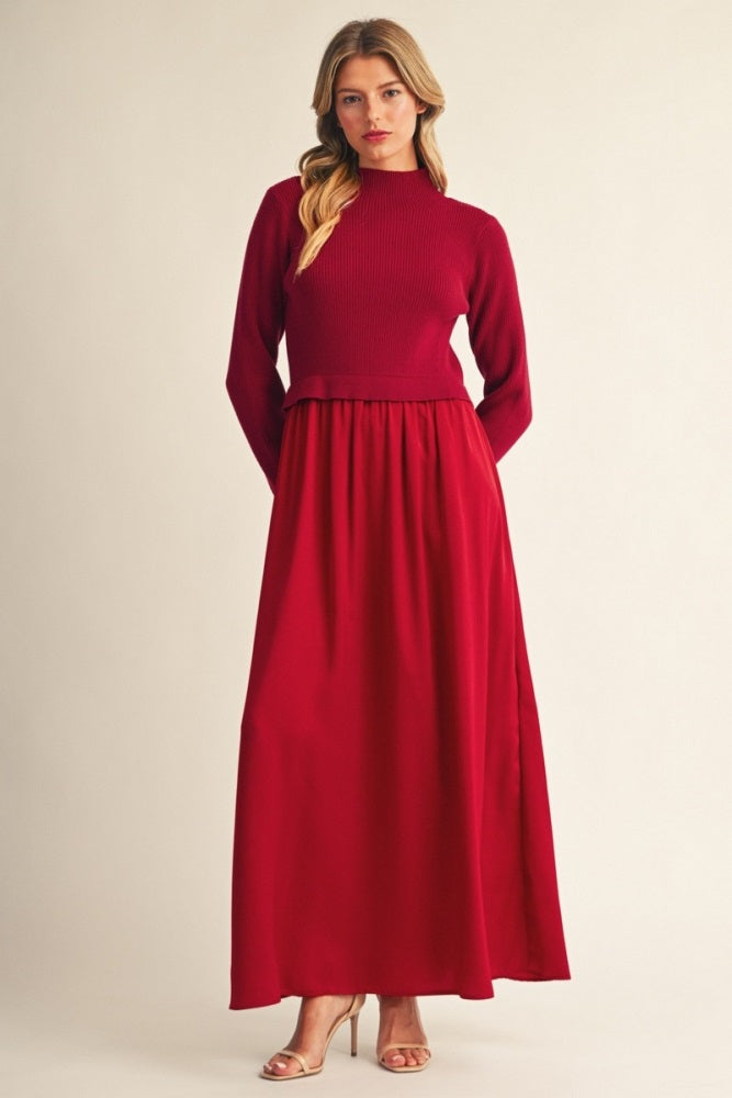 woman wearing a burgundy long sleeve maxi dress with a ribbed top and flowy skirt