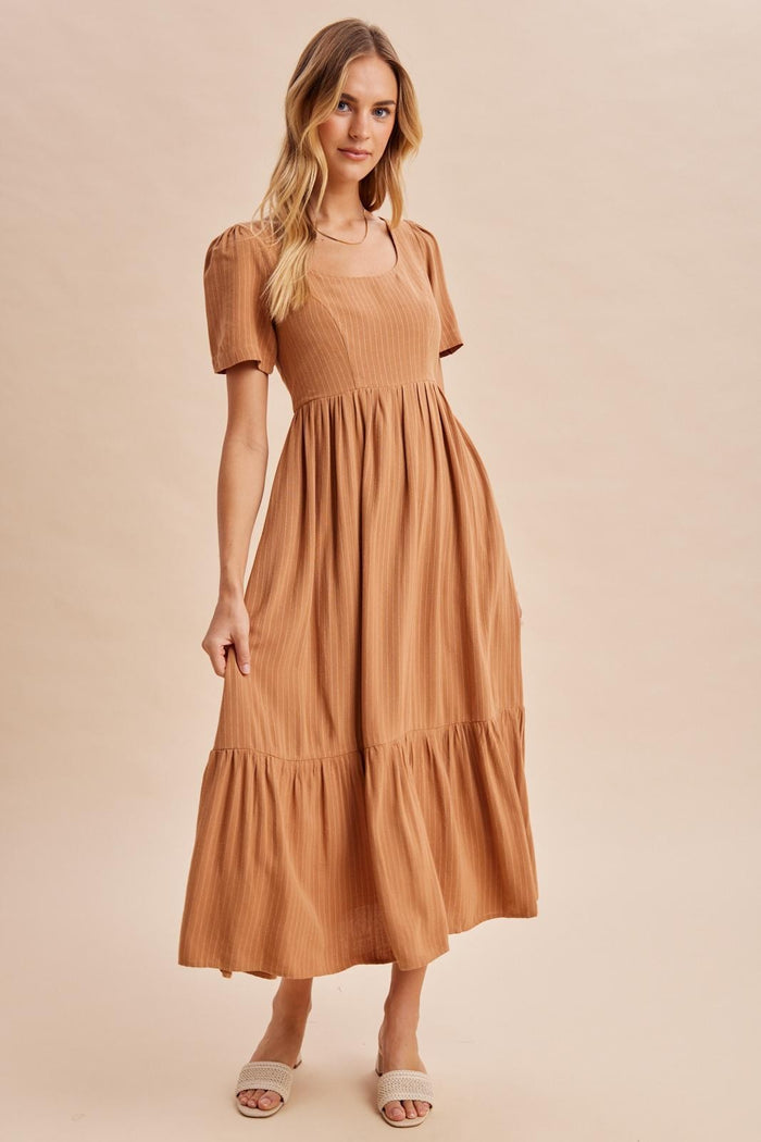 woman wearing a brown tiered maxi dress with short sleeves and a square neckline