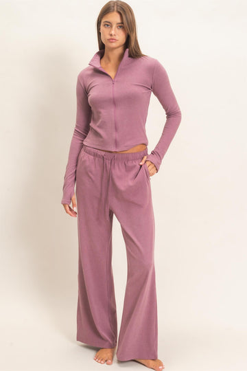 woman wearing a dusty rose zip-up long sleeve top and matching wide-leg lounge pants