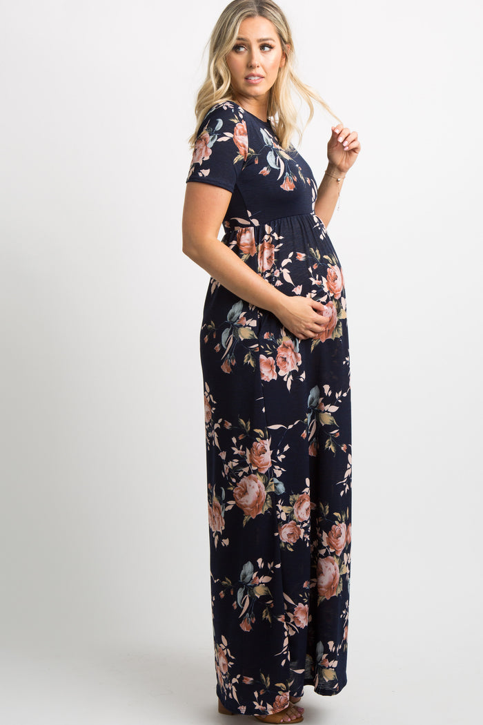 Pregnant woman wearing a navy blue floral print short sleeve maternity maxi dress