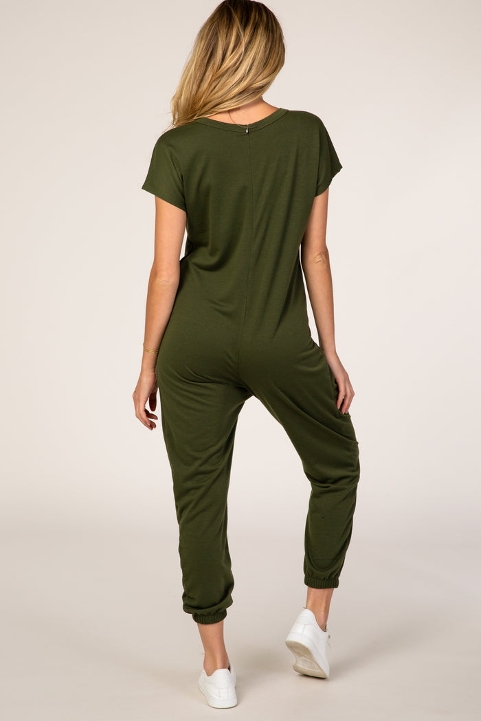 woman wearing a green maternity jumpsuit with short sleeves and tapered pants, showing a relaxed fit from the back
