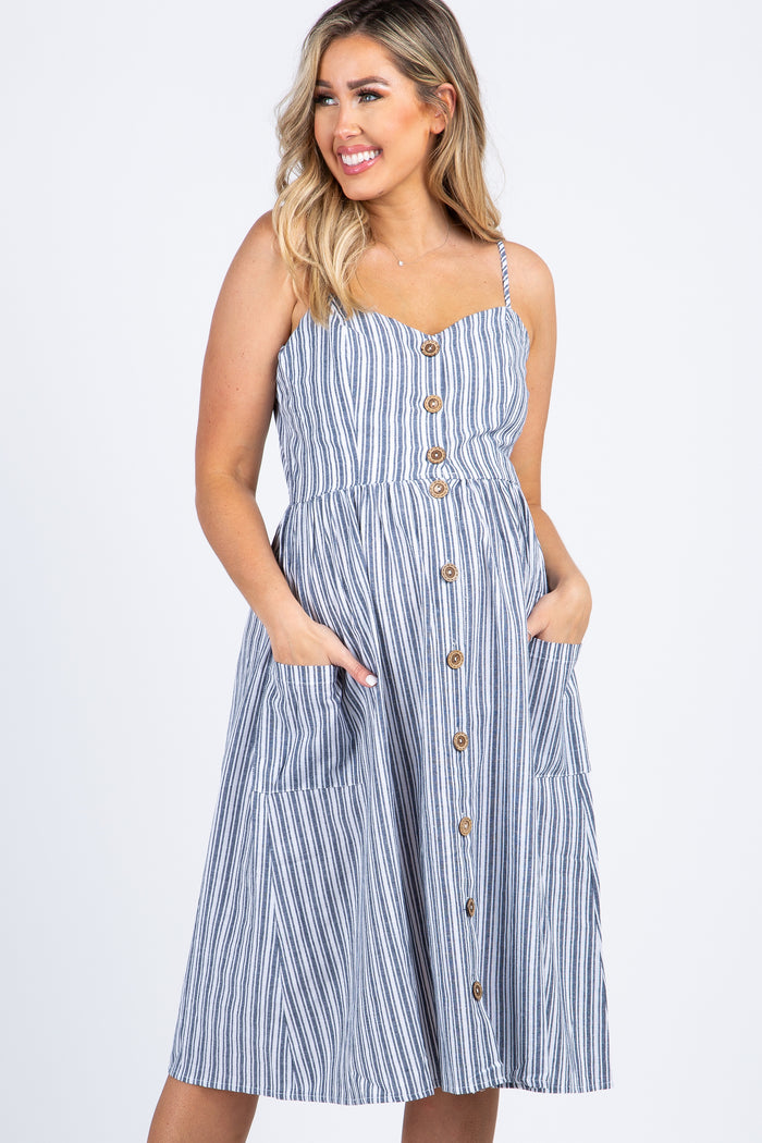 woman wearing a blue and white striped midi dress with buttons and pockets against a white background