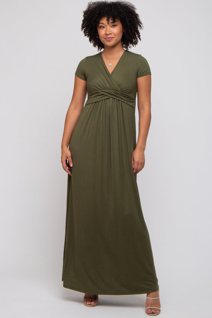 woman wearing an olive green short sleeve maxi dress with a wrapped bodice and a flowing skirt