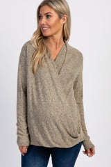 woman wearing a light brown wrap maternity top with long sleeves and a visible baby bump