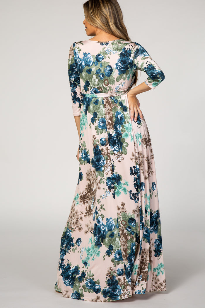 woman wearing a floral maxi dress with three-quarter sleeves in shades of blue and pink, seen from the back