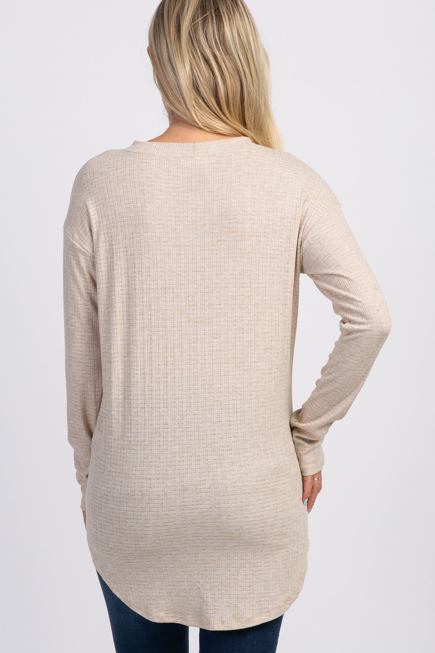 woman wearing a beige long sleeve maternity top with a textured finish, visible from the back