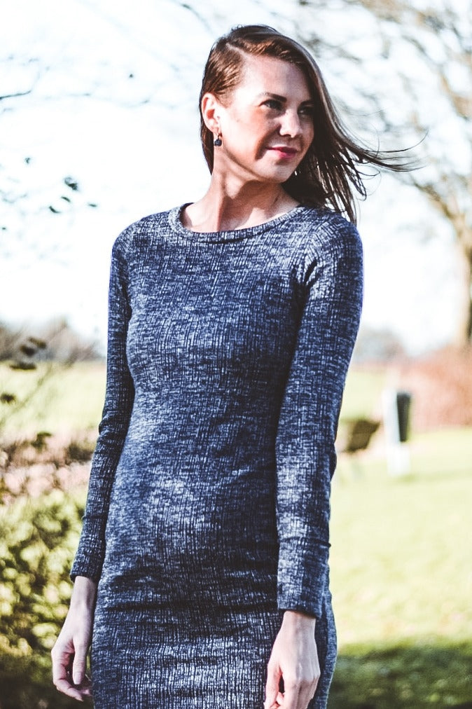 woman wearing a dark gray maternity long sleeve dress that highlights her baby bump
