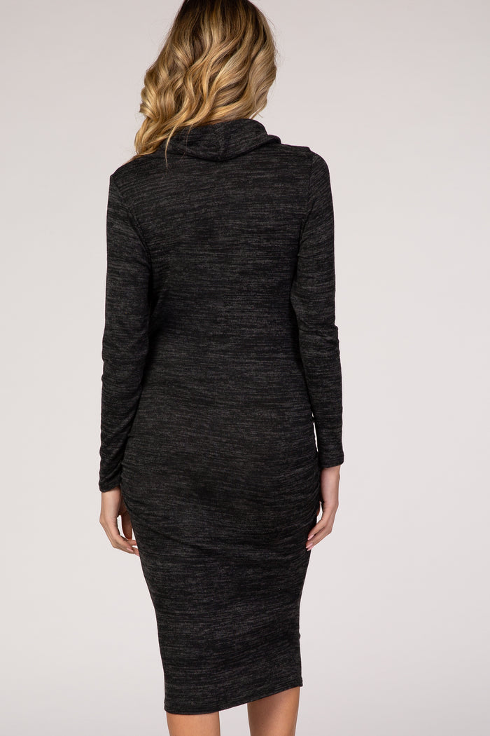woman wearing a dark gray maternity dress with long sleeves and cowl neck, showing a fitted silhouette from the back