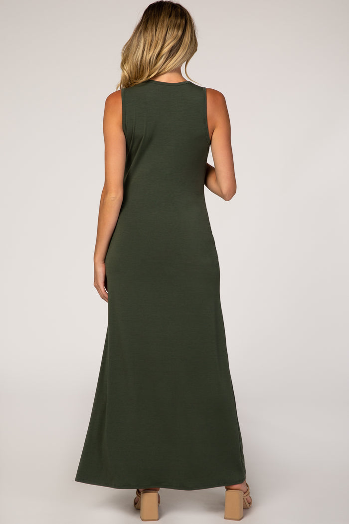 back view of a woman wearing a sleeveless olive green maxi dress and tan block heel sandals