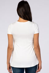 woman seen from the back wearing a white short sleeve t-shirt with a curved hem and blue jeans