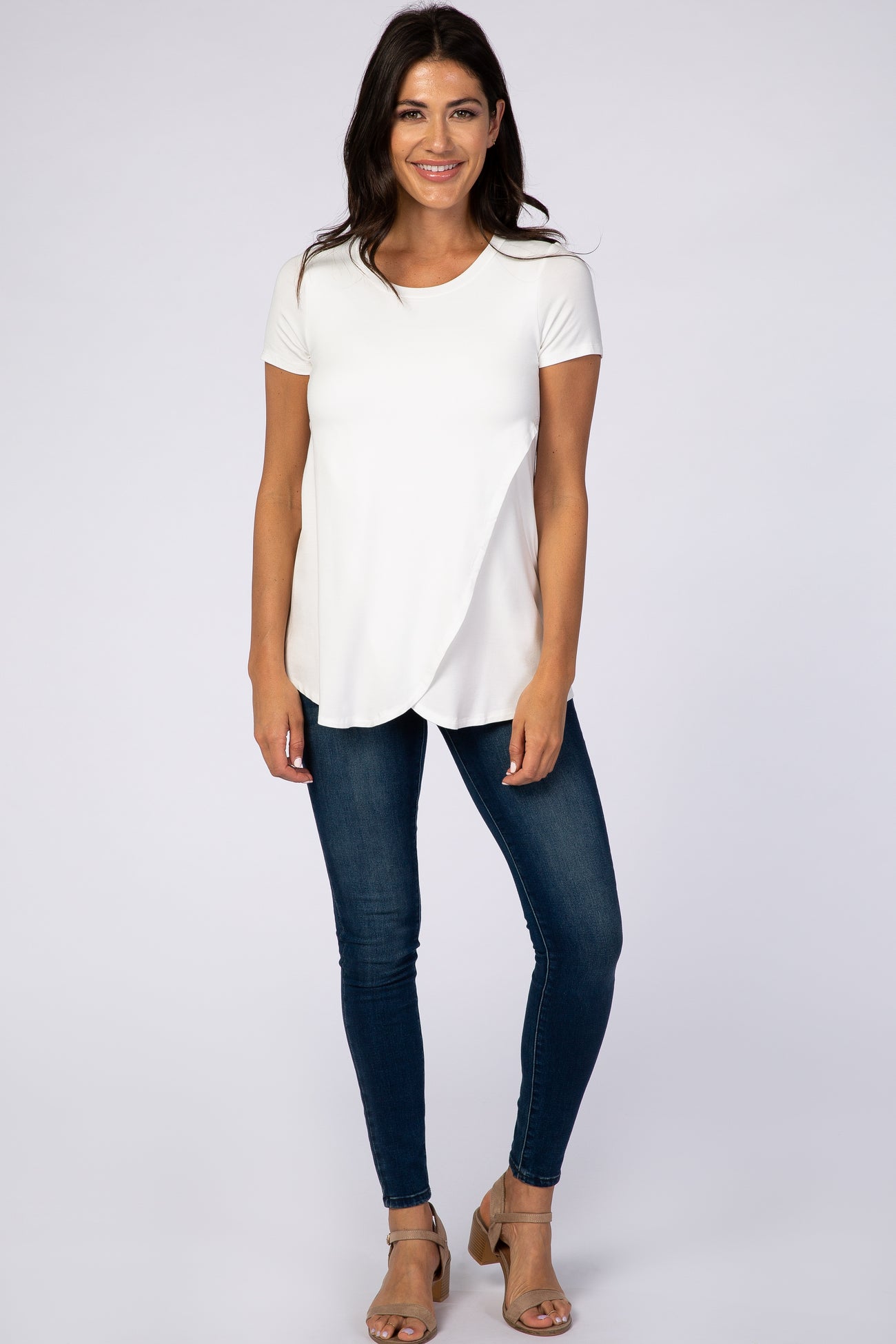 woman wearing white short sleeve nursing top with tulip hem and dark wash skinny jeans