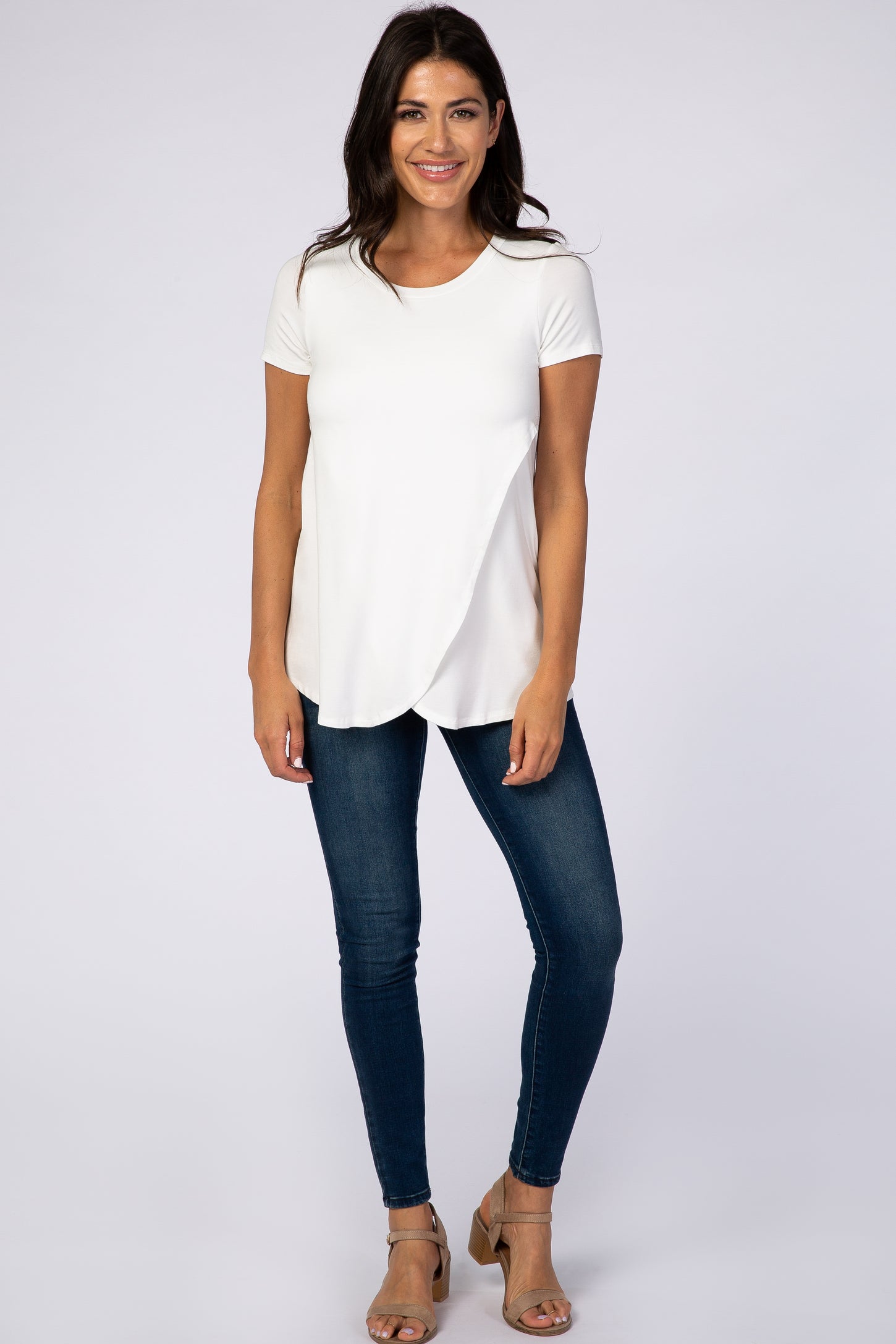 woman wearing white short sleeve nursing top with tulip hem and dark wash skinny jeans